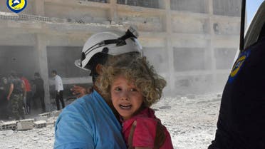 This photo provided by the Syrian Civil Defense group known as the White Helmets, shows a civil defense worker carrying a child after airstrikes hit a school housing a number of displaced people, in the western part of the southern Daraa province of Syria, Wednesday, June 14, 2017. (AP)