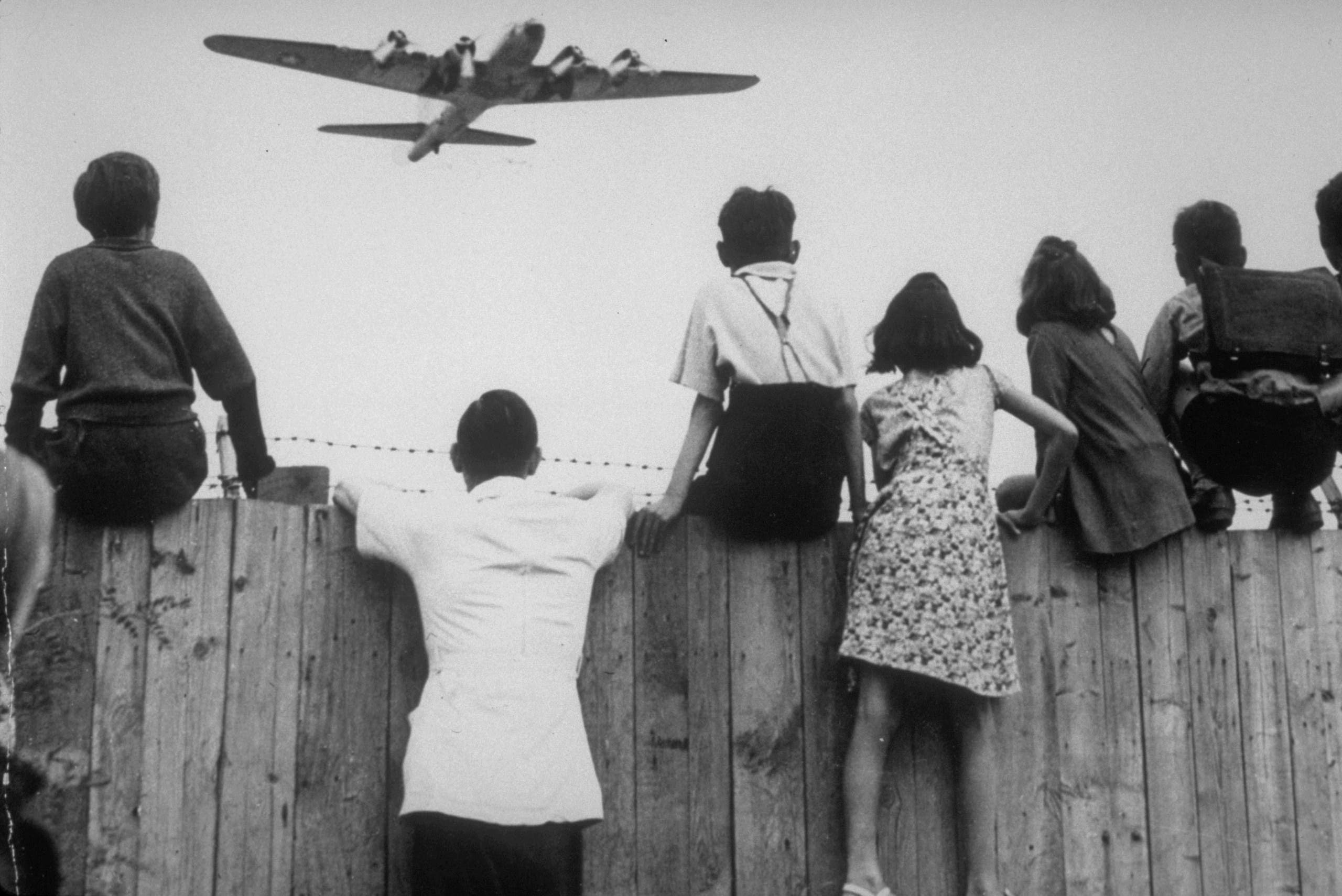 West Berlin children perched on the fence of Tempelhof airport watch the fleets of U.S. airplanes bringing in supplies in 1948 to circumvent the Russian blockade of land and waterways. (AP)