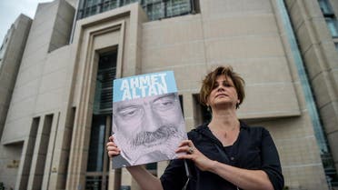 A journalist poses with a portrait of Ahmet Altan in front of the Istanbul courthouse on June 19, 2017. (AFP)