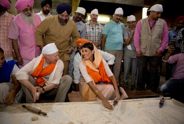 Nikki Haley talks with US ambassador to India Kenneth I. Juster while they try their hands on making Indian bread during their visit to a Gurdwara Sis Ganj Sahib, a Sikh temple, in New Delhi, on June 28, 2018. (AP)