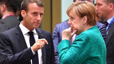 French President Emmanuel Macron, left, speaks with German Chancellor Angela Merkel during a round table meeting at an EU summit in Brussels, Thursday, June 28, 2018. AP