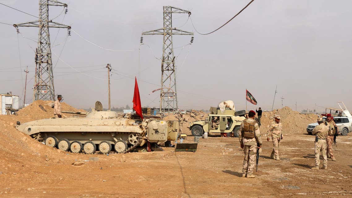 Iraqi forces stand guard near the al-Qaim border crossing between Syria and Iraq on November 8, 2017. Iraq's authorities are now battling the final pockets of jihadists in their last footholds around the town of Al-Qaim, and Syrian troops are also approaching, hemming them in on their side of the frontier.