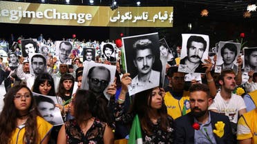 People hold pictures of relatives killed by the Mohllas regime, during "Free Iran 2018 - the Alternative" event on June 30, 2018 in Villepinte. (Reuters)