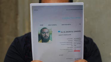 An Iraqi man holds printed profiles of Abu Bakr al-Baghdadi released by Iraqi authorities on February 6, 2018. (AFP)