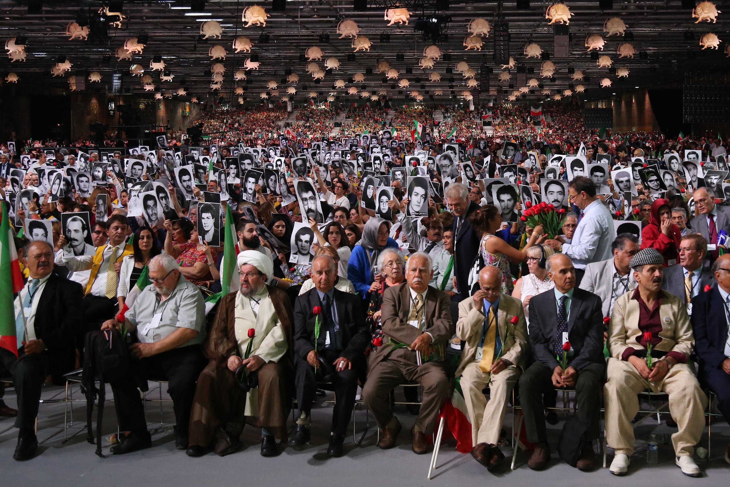People hold pictures of relatives killed by Mohllas regime during “Free Iran 2018” event in Villepinte, north of Paris, on June 30, 2018. (AFP)