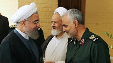 A handout picture provided by the office of Iranian President Hassan Rouhani shows him (L) shaking hands with the commander of the Iranian Revolutionary Guard's Quds Force. (AFP)