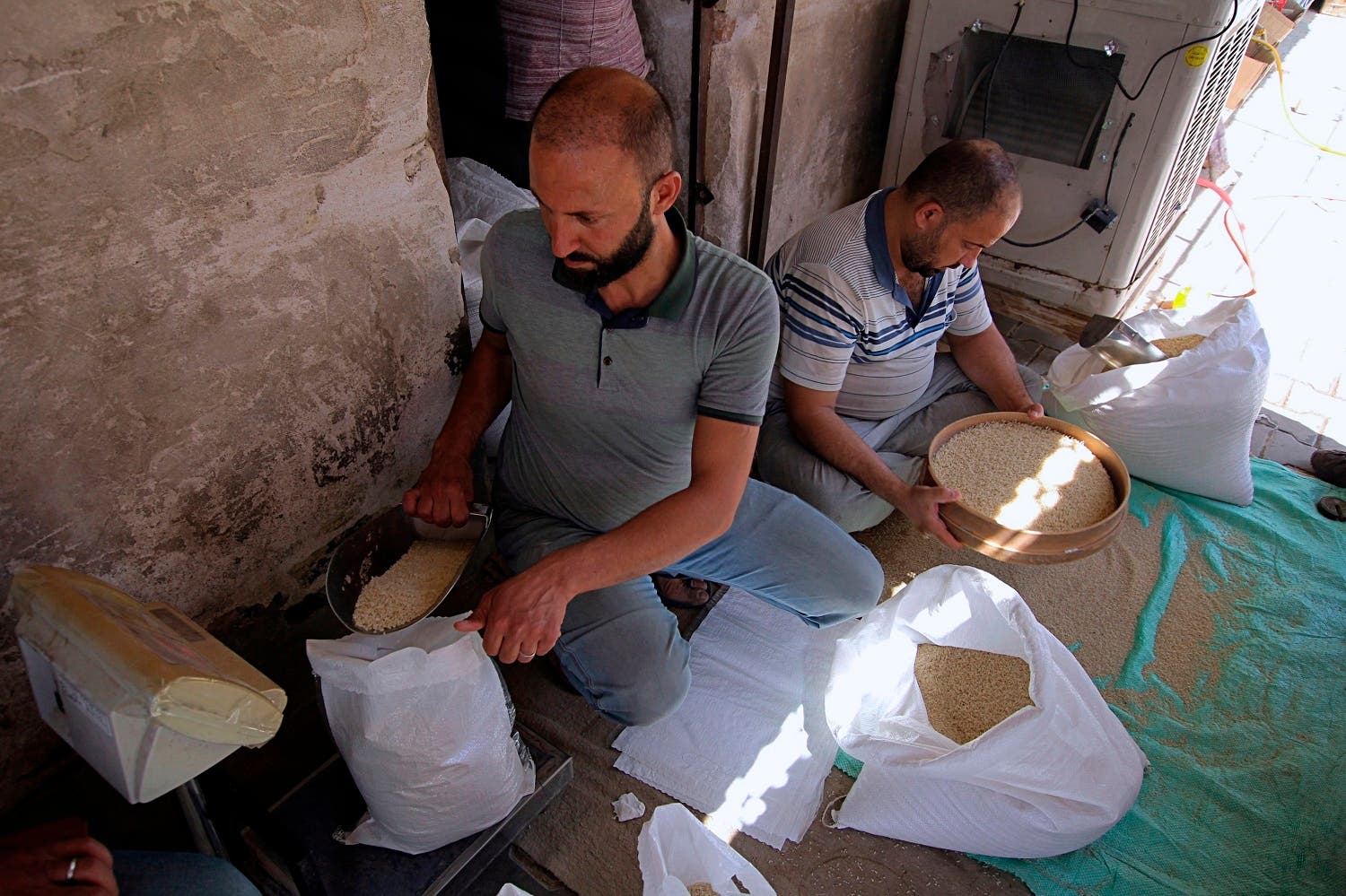 In this June 26, 2018 photo, farmers prepare the last of their remaining rice crop to sell, in the Iraqi town of Mishkhab south of Najaf. (AP)