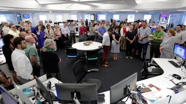 Employees gather in the newsroom of the New York headquarters of The Associated Press, for a moment of silence for the five employees of the Capital Gazettewho were killed a week ago. (AP)