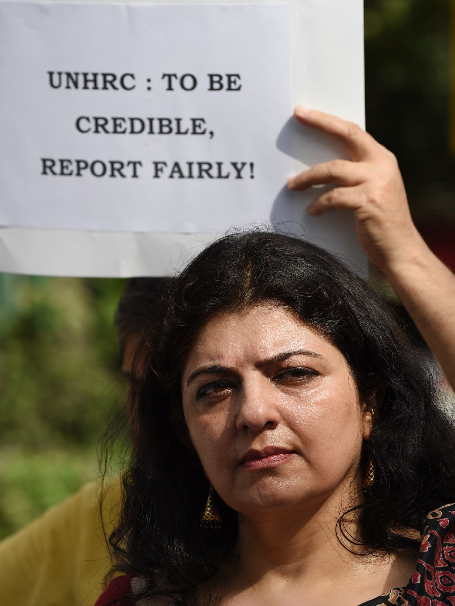 A Kashmiri Hindu protester holds a placard during a protest following the report of Office of the United Nations High Commissioner for Human Rights (OHCHR) outside the UN office in New Delhi on June 25, 2018. (AFP)