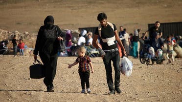 Syrians walk carrying their belongings on August 22, 2017 after crossing the Syria-Jordan border near the town of Nasib as they return to their homes following a US-Russia ceasefire brokered in three southern provinces, Daraa, Quneitra, and Sweida earlier in the year. Mohamad ABAZEED / AFP