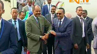 Ethiopia's Prime Minister Abiy Ahmed, centre right is welcomed by Erirea's President Isaias Afwerki as he disembarks the plane, in Asmara, Eritrea. (ERITV via AP)