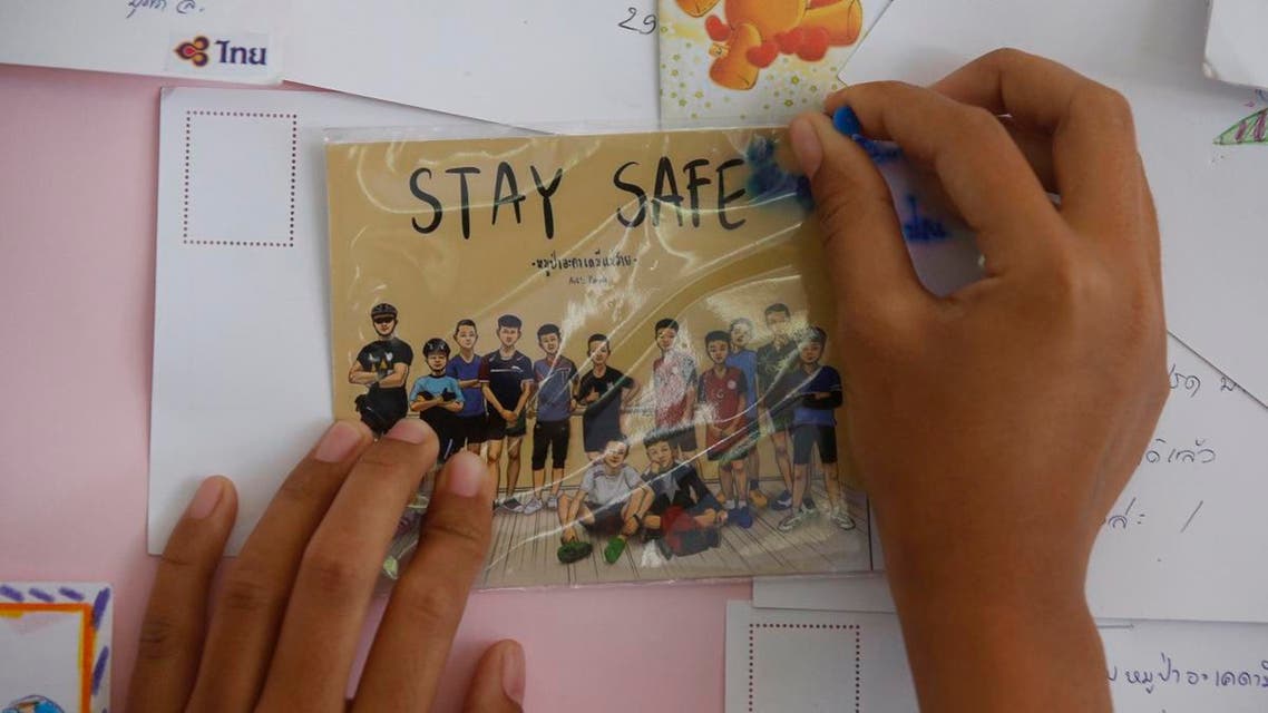 A Thai well wisher puts a poster to pray for boys and their soccer coach who have been trapped since June 23, in Mae Sai, Chiang Rai province. (AP)