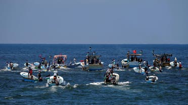 People ride boats as a boat carrying Palestinian patients and students sails towards Europe aiming to break Israel's blockade on Gaza, at the sea in Gaza July 10, 2018. REUTERS