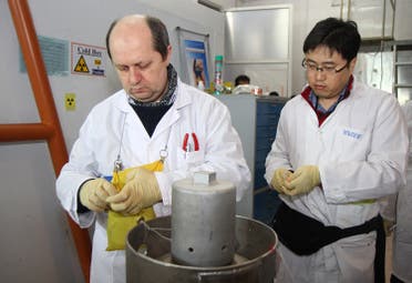Unidentified IAEA inspectors seal after disconnecting the connections between the twin cascades for 20 percent uranium production at nuclear power plant of Natanz on January, 20, 2014. (AFP)