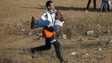 A medic evacuates a Palestinian boy after inhaling tear gas fired by Israeli troops during a protest at the Israel-Gaza border in the southern Gaza Strip July 6, 2018. (Reuters)