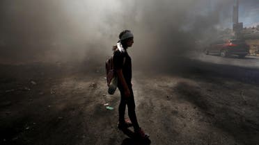 A Palestinian girl stands amongst smoke during clashes with Israeli troops near the Jewish settlement of Beit El, near Ramallah, in the occupied West Bank on June 29, 2018. (Reuters)