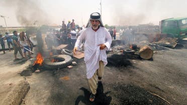 Iraqi protesters burn tires and block the road at the entrance to the city of Basra. (Reuters)