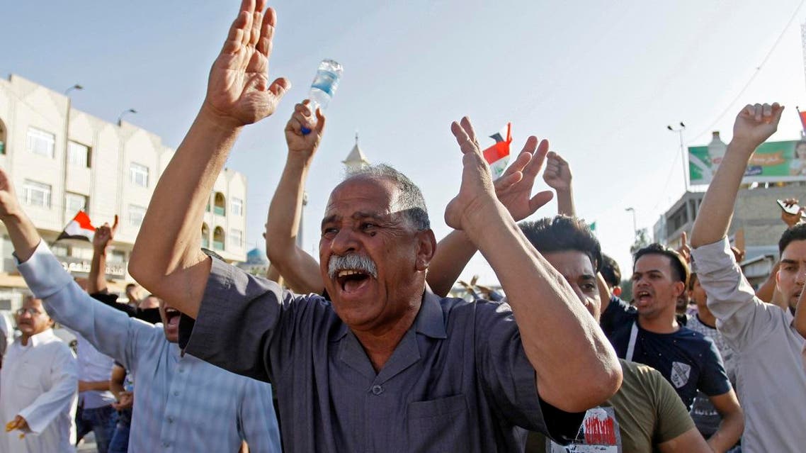 Iraqis shout slogans while gathering during a demonstration in the central shrine city of Najaf on July 13, 2018. (AFP)