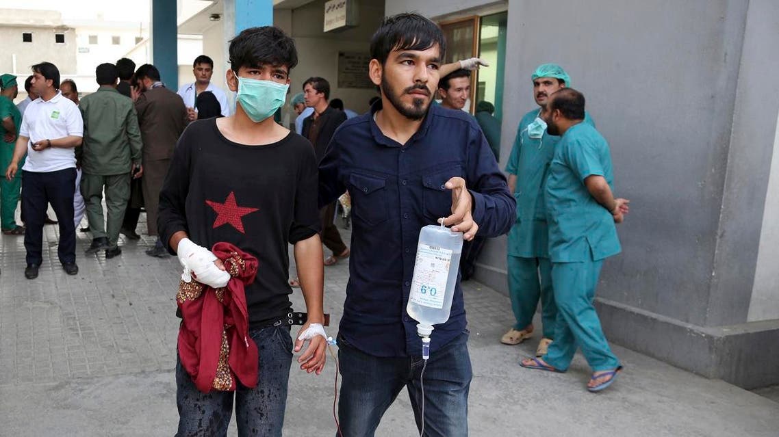 An injured youth is escorted to a hospital following a deadly attack outside the Rural Rehabilitation and Development Ministry in Kabul. (AP)