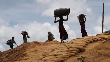 Rohingya girls carry firewood on their heads as they make their way through Kutupalong refugee camp in Bangladesh on June 28, 2018. (AP)