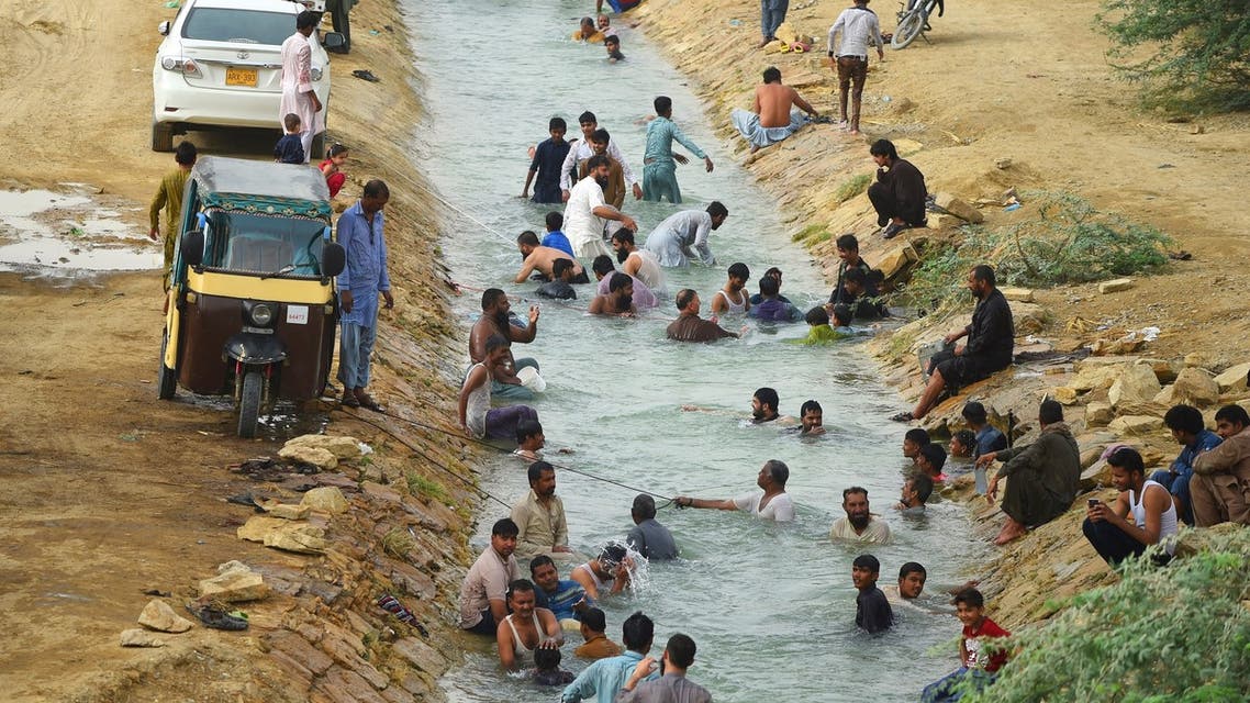 Pakistani residents cool off at a canal during heatwave as temperatures reach 44 degrees celsius in Karachi on May 30, 2018.