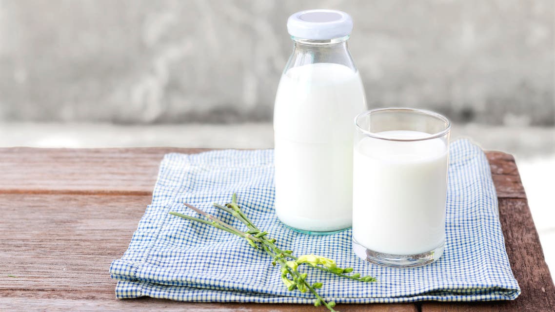 Glass of milk and bottle of milk on the wood table. - Stock image