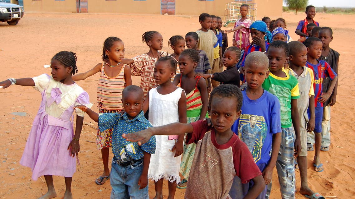 Children get ready to enter a class room in Yakouta on June 10, 2009. In Burkina Faso's arid northern region classes burst at the seams at the start of the school year but as the year progresses more and more parents take their children out of school: the boys leave to herd cattle and many girls get married off early. In the last few years teachers, parents and non-governmental organisations and the local authorities have come up with a number of new ways to fight against early school leaving.