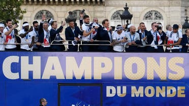 France's national soccer team players take pictures with their mobile phones as they celebrate with teammates on the roof of a bus. (Reuters)