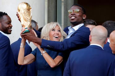 Brigitte Macron, the wife of French President Emmanuel Macron, and player Paul Pogba hold the trophy before a reception to honour the France soccer team after their victory in the 2018 Russia Soccer World Cup, at the Elysee Palace in Paris. (Reuters)