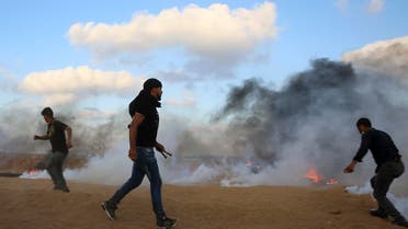 Protesters try to throw back teargas canisters fired by Israeli troops near the fence of the Gaza Strip border with Israel, during a protest east of Khan Younis, southern Gaza Strip, Friday, July 20, 2018. (AP)