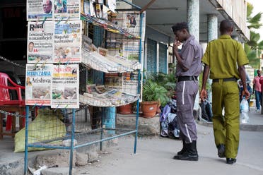 A security guard reads the newspapers' headlines at a newsstand in Mwanza. (AFP)