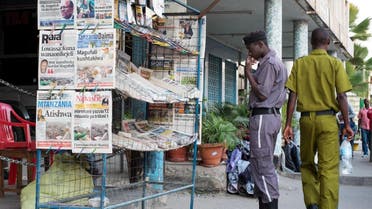 A security guard reads the newspapers' headlines at a newsstand in Mwanza. (AFP)