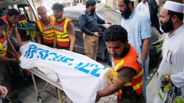 Rescue workers move the body of Ikramullah Gandapur, a candidate of the Pakistan Tehreek-e-Insaf (PTI), or Pakistan Justice Movement, who was killed in a suicide attack, outside hospital morgue in Dera Ismail Khan. (Reuters)