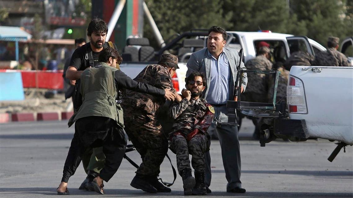 Afghan security personnel carry an injured comrade after an attack near the Kabul International Airport in Afghanistan on July 22, 2018. (AP)