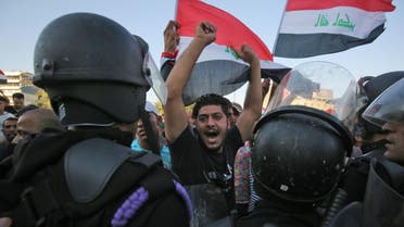 Iraqi protesters shout slogans and wave national flags as they facing security forces during clashes at a demonstration against unemployment and a lack of basic services in the capital Baghdad's Tahrir Square. (Reuters)