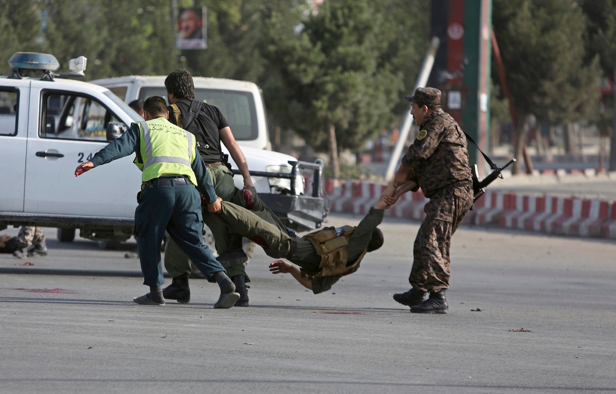 Afghan security personnel carry an injured officer after an attack near the Kabul Airport, in Kabul, Afghanistan, Sunday, July 22, 2018. (AP)