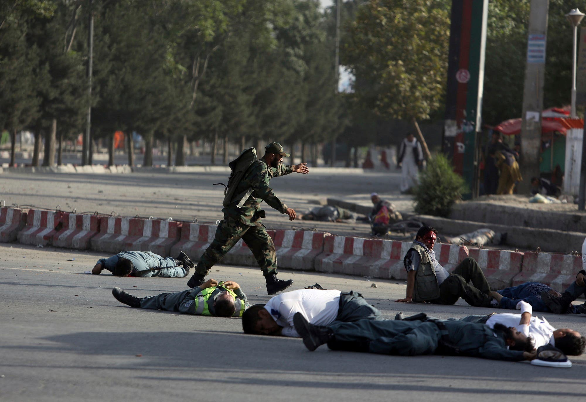 Afghan security personnel and traffic police lie on the ground after a suicide attack near the Kabul Airport, in Kabul, Afghanistan, Sunday, July 22, 2018. (AP)