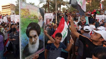 Protesters chant in support the Shiite spiritual leader Grand Ayatollah Ali al-Sistani, in the poster at left, during a demonstration. (AP)