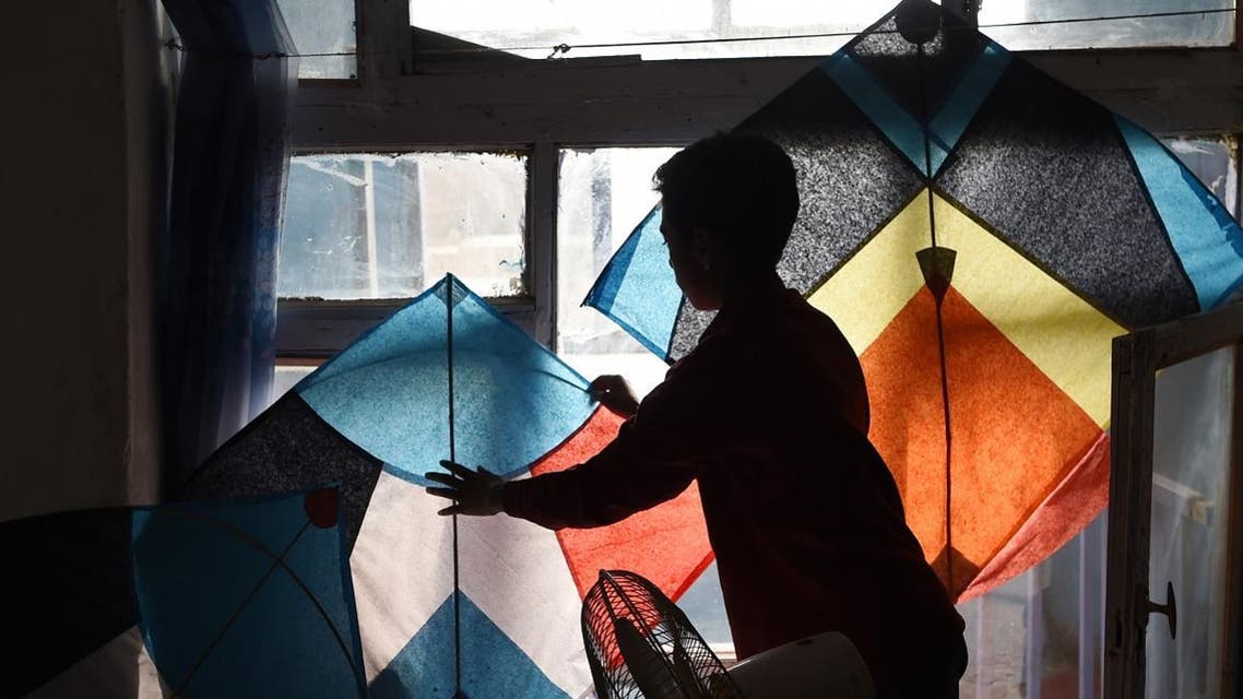 Shohaib, a son of kite vendor Halim Muhammadi, sorts out kites in their home in Kabul. (AFP)