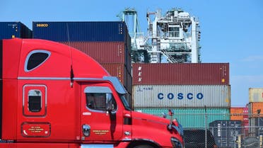 A container delivery truck passes containers stacked at the Port of Long Beach in Long Beach, California on July 6, 2018, including one from COSCO, the Chinese state-owned shipping and logistics company. (AFP))