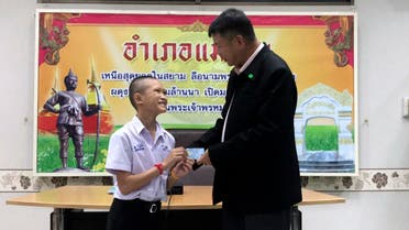 Mongkol Boonpiam, left, receives an identity card denoting Thai citizenship (Chiang Rai Public Relations Office via AP)