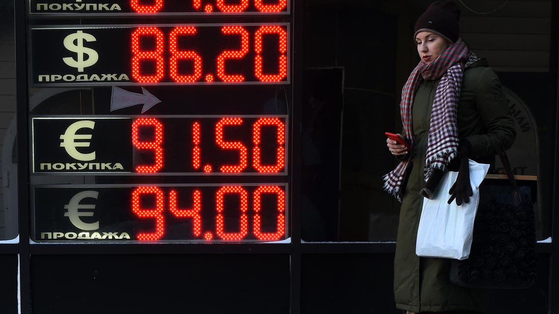 A woman walks past a board listing foreign currency rates against the Russian ruble in Moscow, on January 21, 2016. (File photo: AFP)