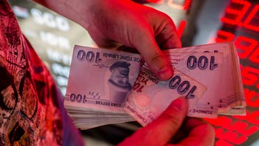 A money changer counts Turkish lira banknotes at a currency exchange office in Istanbul, on August 8, 2018. (AFP)