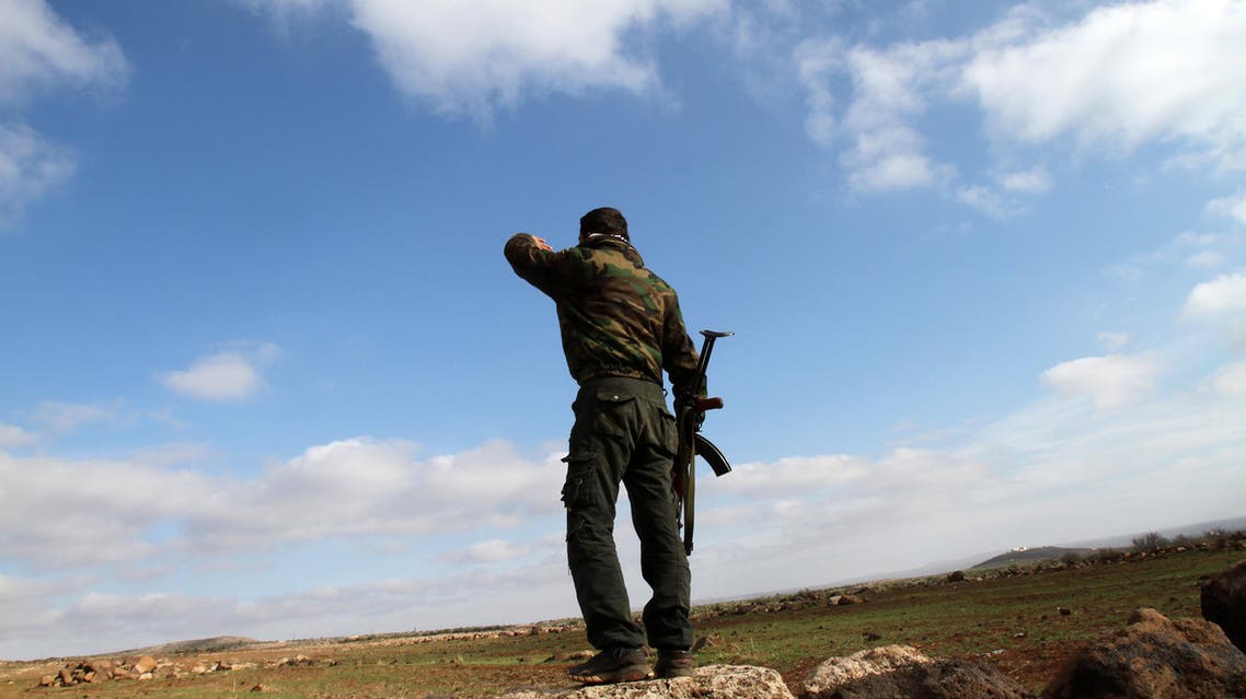 A Syrian soldier looks over at the town of Daraa from his position in the southern city of Sweida on January 23, 2013. Bloodstained clothes, charred facades of homes and collapsed buildings show the intensity of the fighting between the army and residents of the Druze mountain in southern Syria and the rebels of Daraa. AFP PHOTO/ANWAR AMRO
