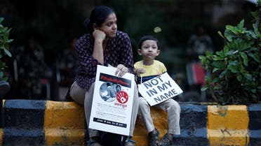 A woman and her son hold placards during a protest against, what the demonstrators say, recent mob lynchings across the country, in New Delhi. (Reuters)
