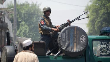 An Afghan security personnel stands guard atop a vehicle near the site of suicide attack as an ongoing attack between Afghan security force and suicide attackers in Jalalabad on July 31, 2018. (AFP)