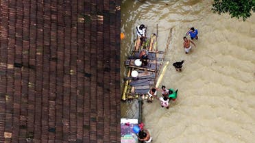 People wait for aid next to makeshift raft at a flooded area in the southern state of Kerala, India, August 19, 2018. (Reuters)
