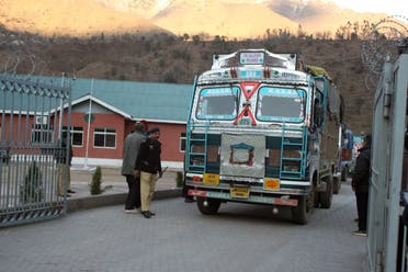 Pakistani policemen make way for Indian trucks as they leave the Trade Facilitation Centre before crossing the border in Chakoti on February 12, 2014. (AFP)
