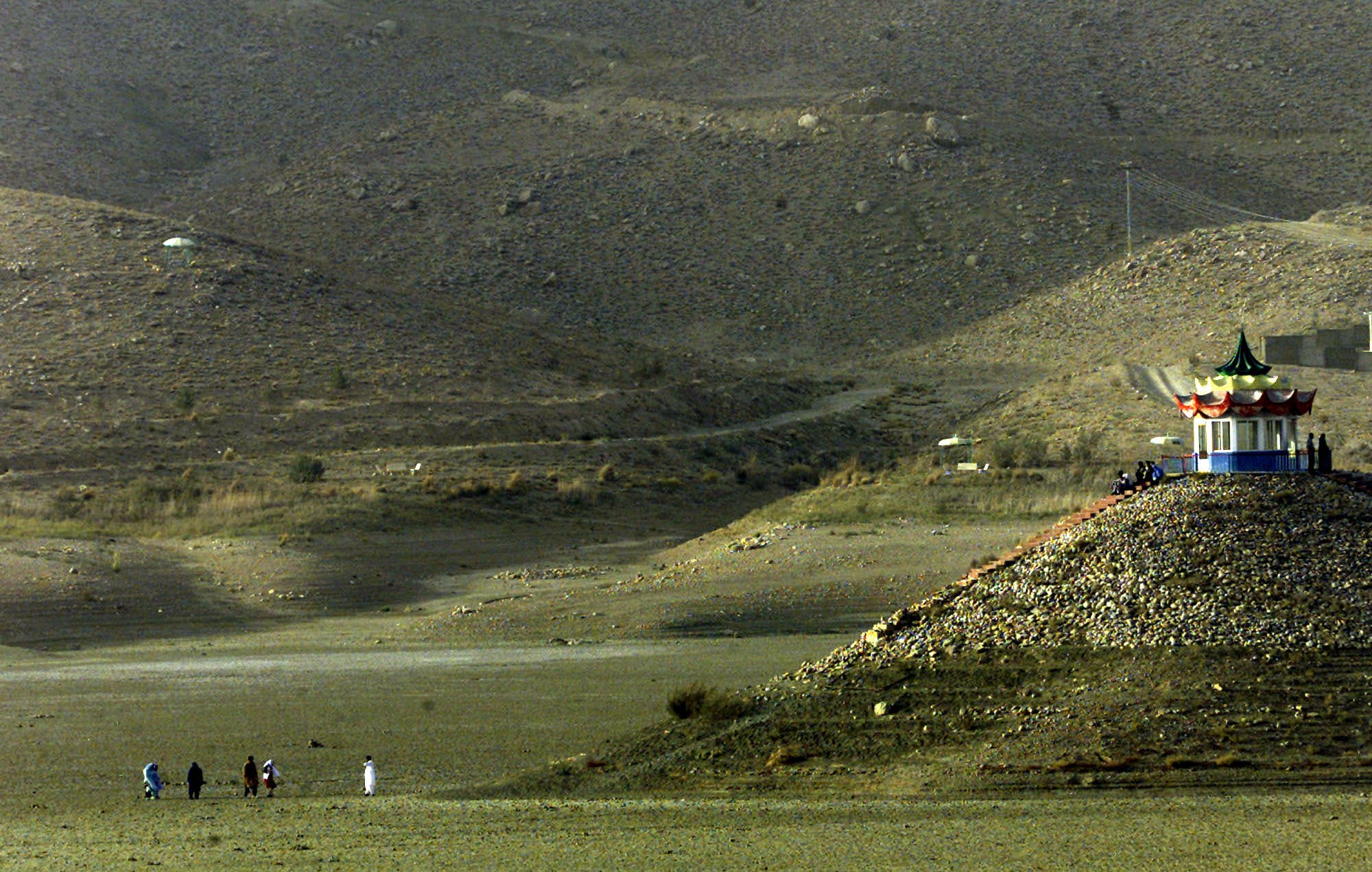 Pakistanis walk towards what was once an island, on the now dried-out Hanna Lake, outside the Baluchistan province capital of Quetta on Oct. 3, 2001. (AP)