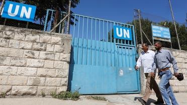 Two Palestinians walking past a school run by UNRWA in Nablus in the West Bank on August 13, 2018. Photo: Abed Omar Qusaini.